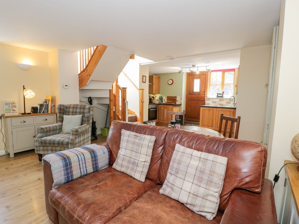A living room with a sofa and an armchair at Woodpecker Cottage in Llangollen