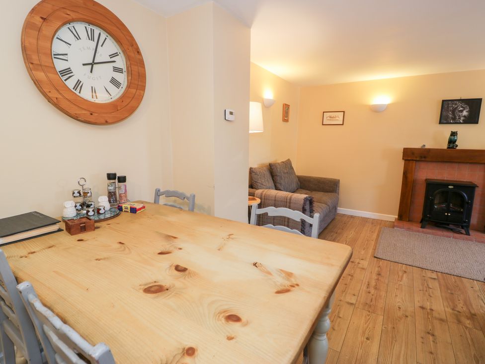 A dining room with a table and chairs at Owl Cottage in Llangollen