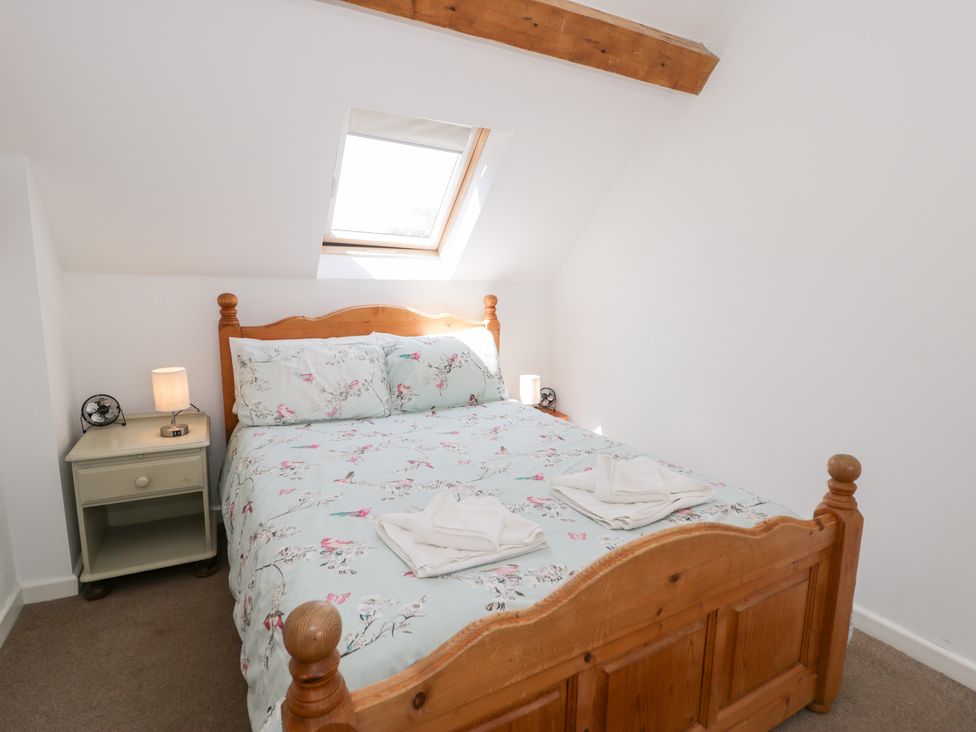 A bedroom with a bed and bedside table at Owl Cottage in Llangollen