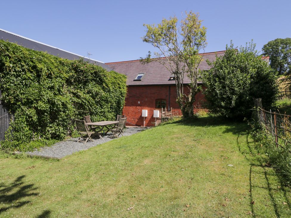 A garden with a table and chairs at Owl Cottage in Llangollen