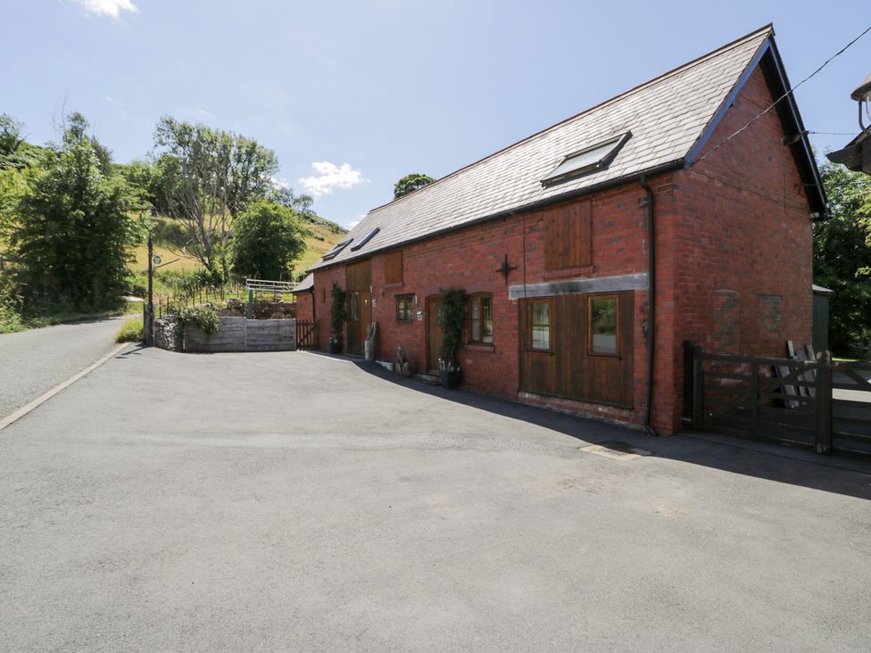A brick building with planters and gate at Owl Cottage in Llangollen