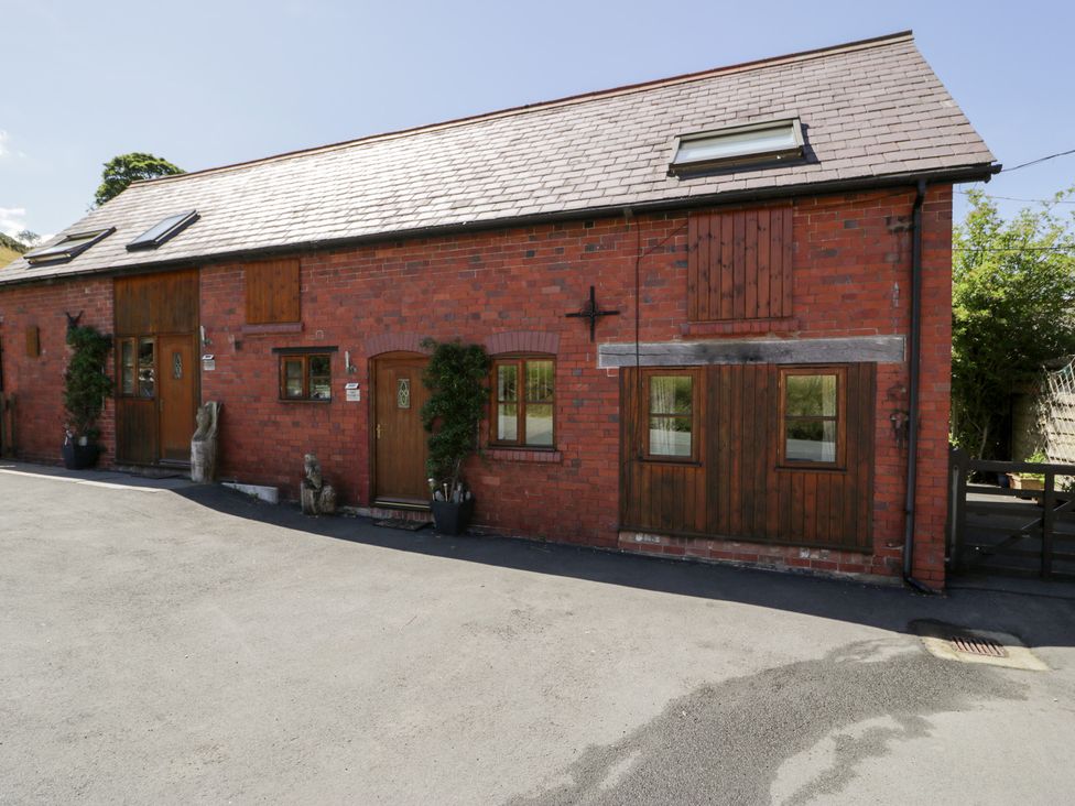 A exterior view of a brick cottage with windows and door at Owl Cottage in Llangollen