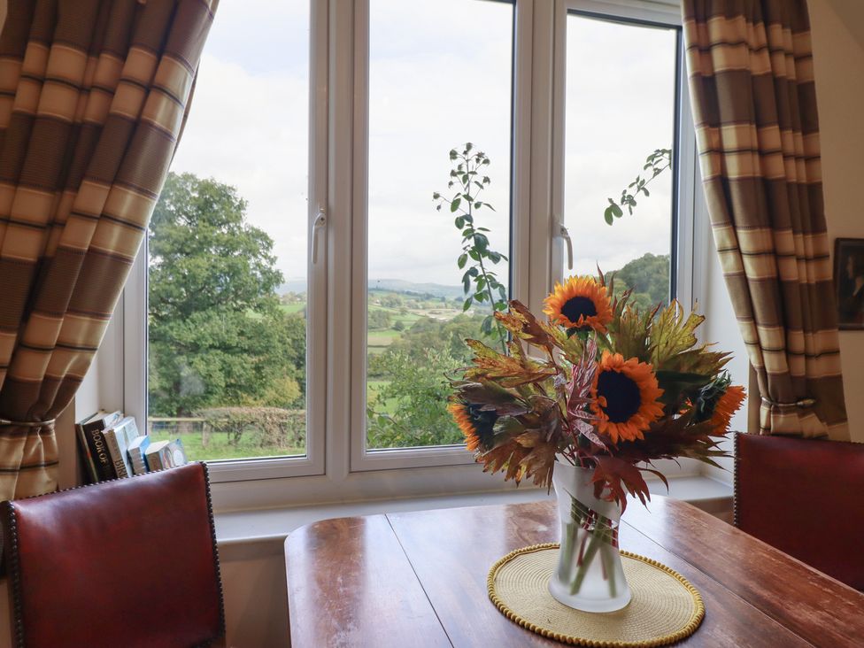 A dining room with a floral arrangement on the table at Upper Pandy Farm Welshpool