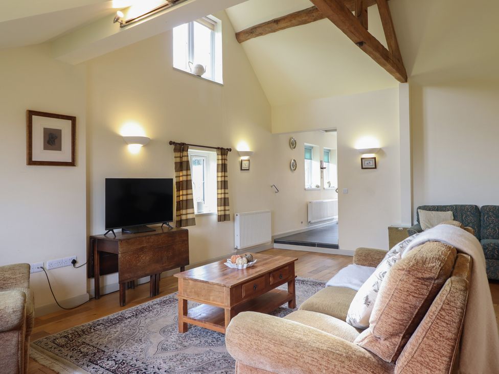A living room with a sofa and television at Upper Pandy Farm in Welshpool