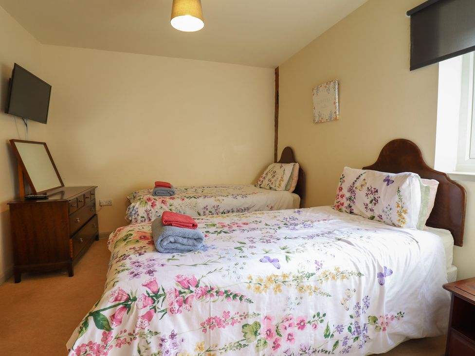 A bedroom with two beds and a television at Upper Pandy Farm in Welshpool
