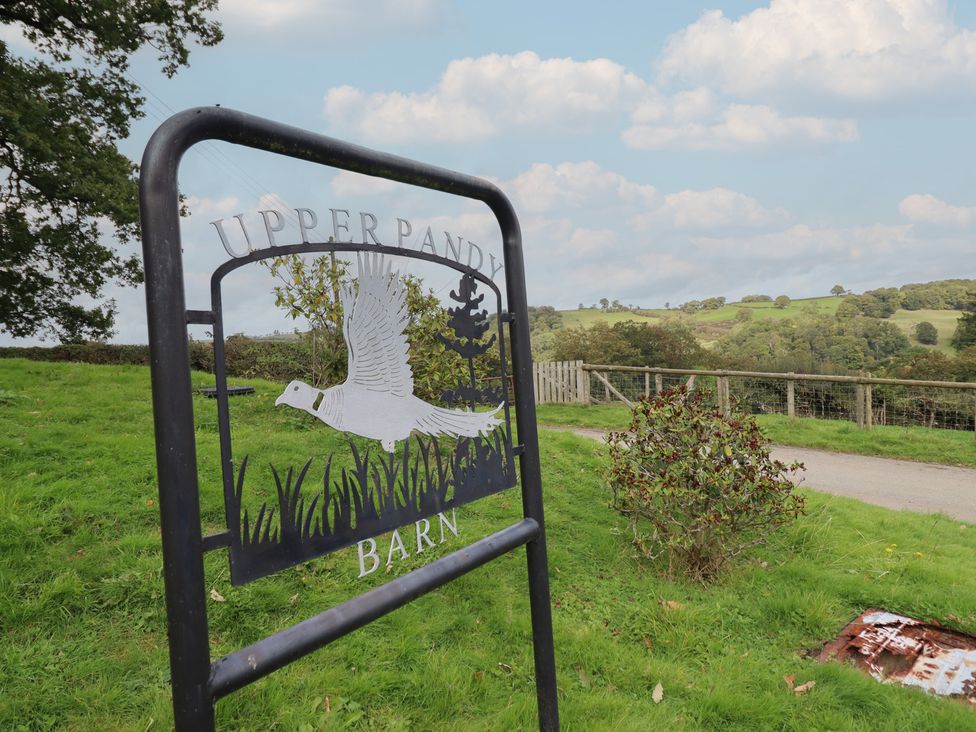 A sign for Upper Pandy Barn in a rural area at Upper Pandy Farm in Welshpool