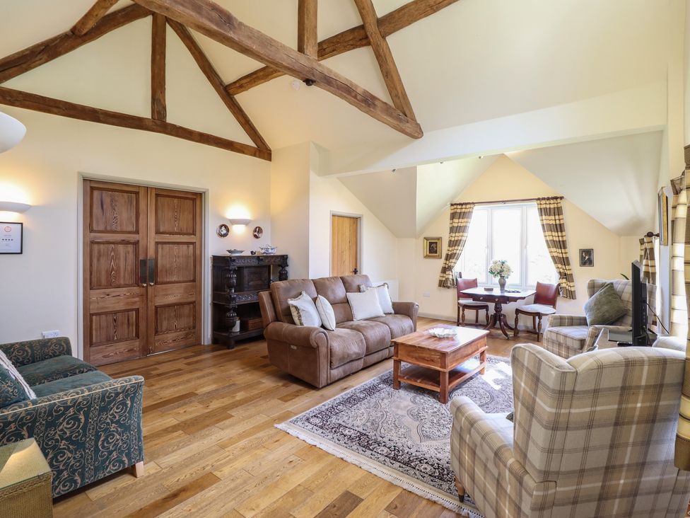 A living room with a sofa and armchairs at Upper Pandy Farm in Berriew near Welshpool