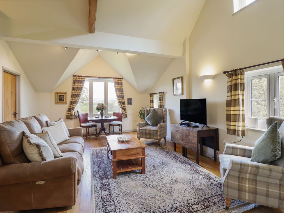 A living room with a sofa and coffee table at Upper Pandy Farm in Berriew near Welshpool