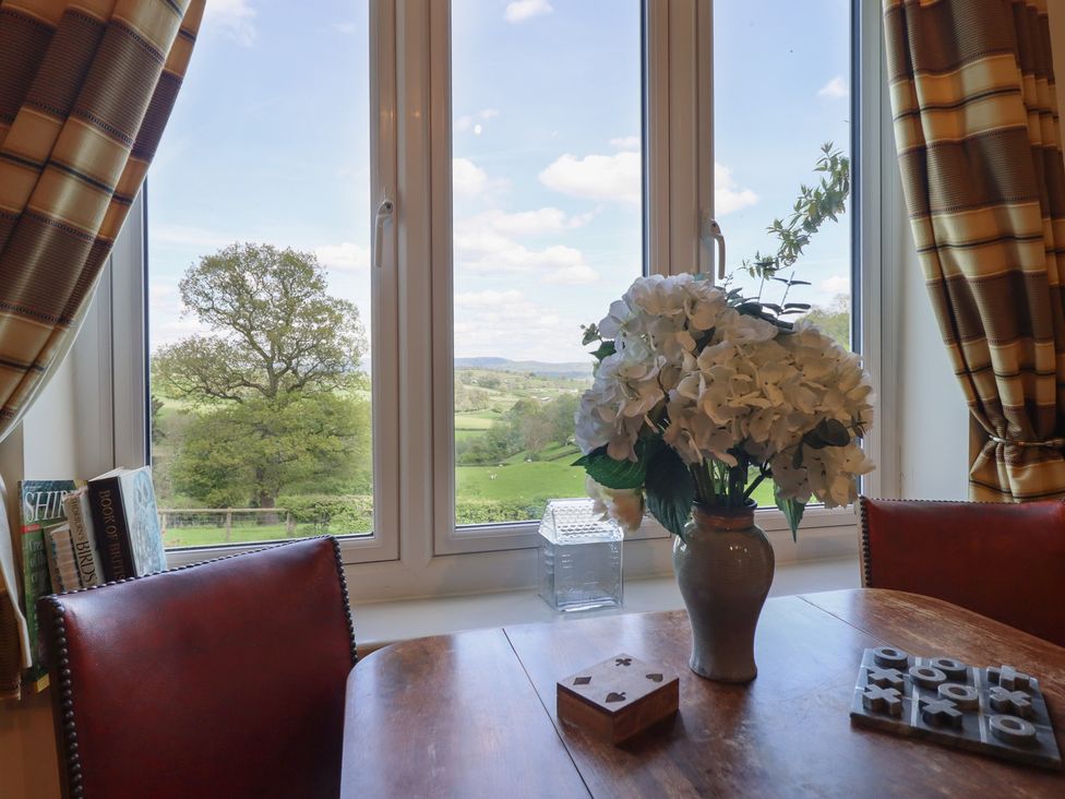 A dining room with a table and flowers at Upper Pandy Farm near Welshpool