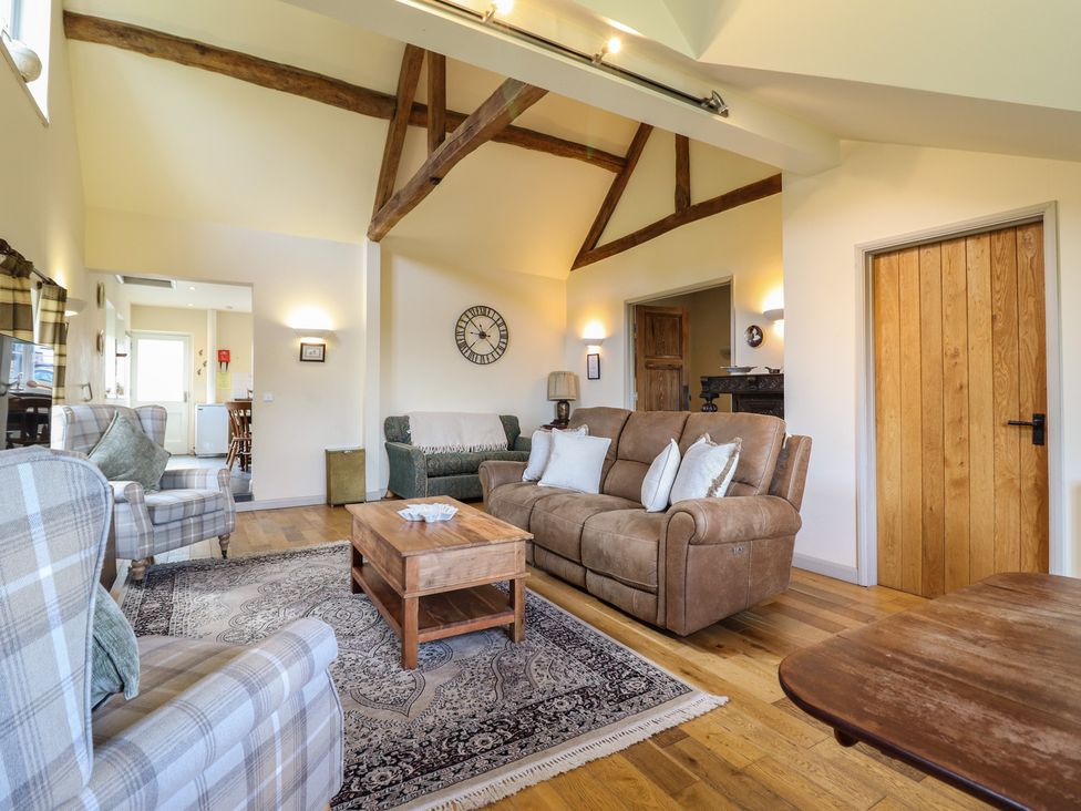 A living room with a sofa and armchairs at Upper Pandy Farm in Berriew near Welshpool