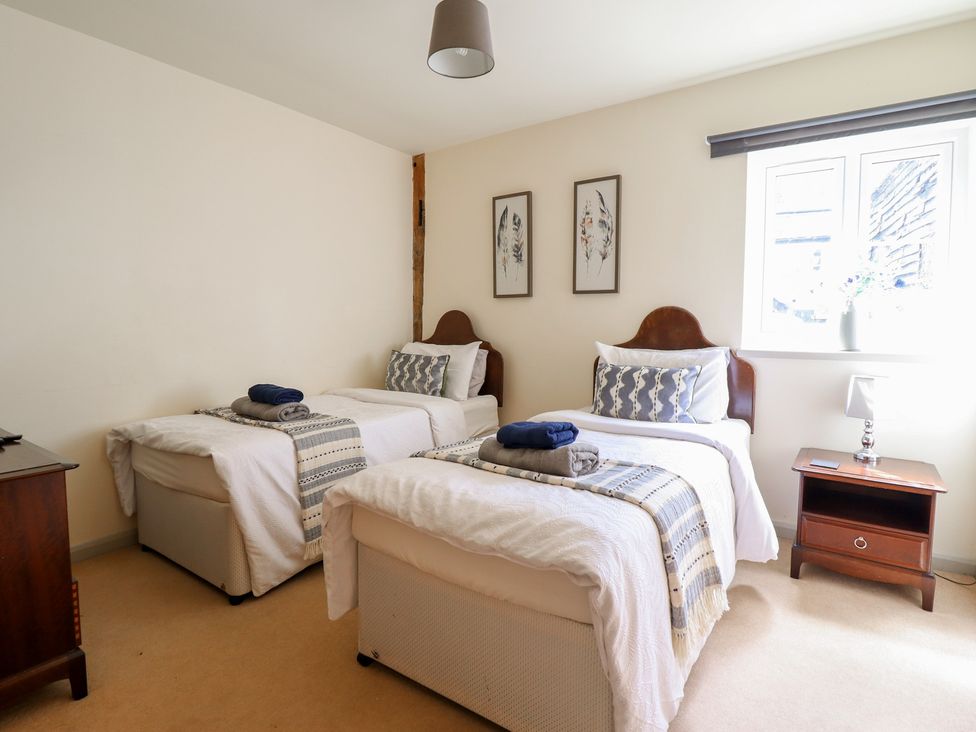 A bedroom with twin beds and a bedside table at Upper Pandy Farm in Berriew near Welshpool