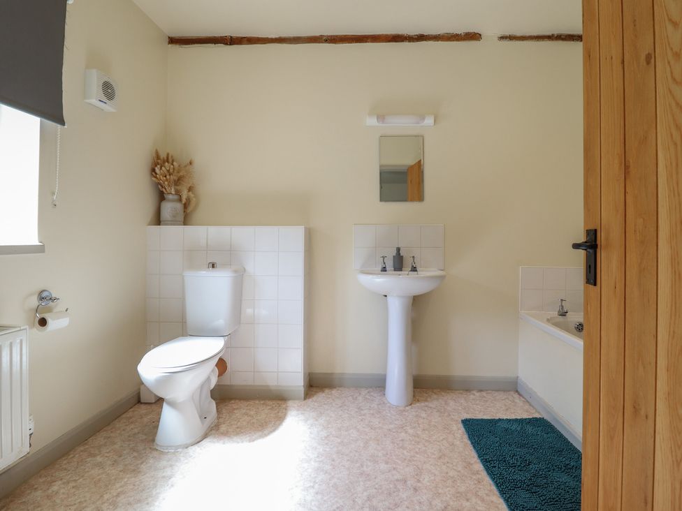 A bathroom with a toilet, sink, and bathtub at Upper Pandy Farm in Berriew near Welshpool