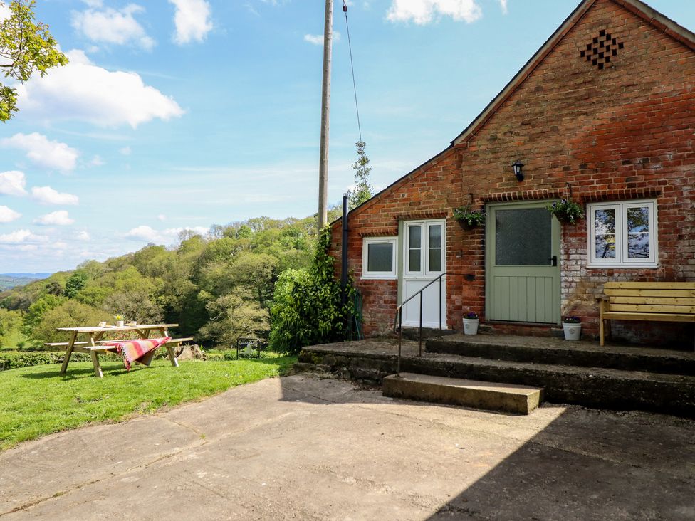 An outdoor area with a table and benches at Upper Pandy Farm in Berriew near Welshpool