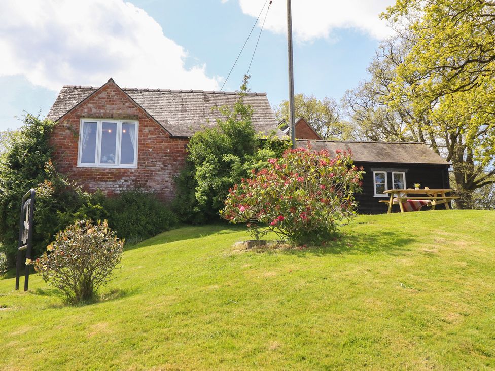 A house with a garden and seating area at Upper Pandy Farm in Berriew near Welshpool