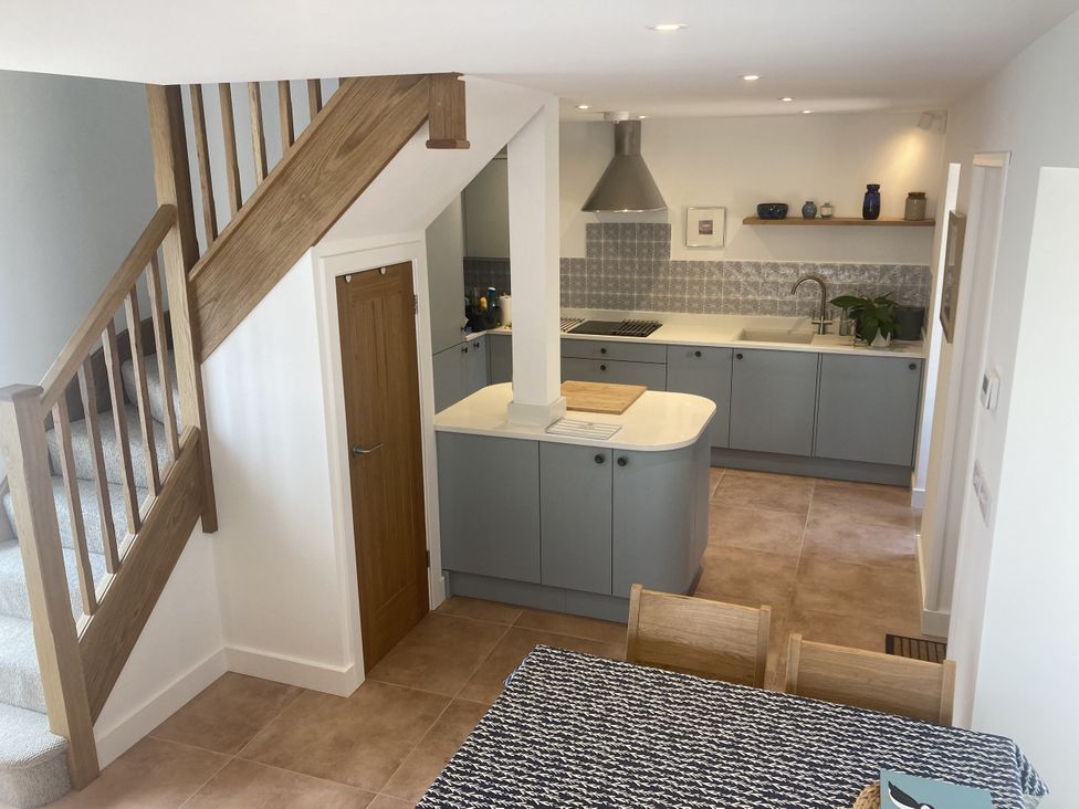 A kitchen with a staircase and dining table at Jams in Lympstone