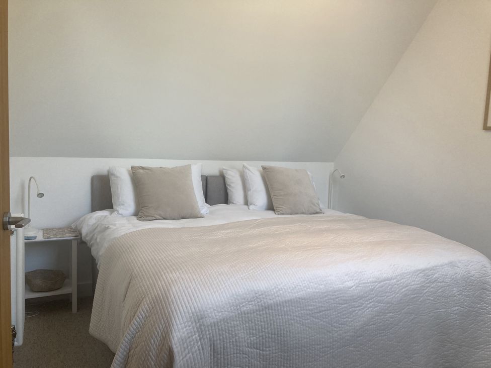 A bedroom with a bed and bedside table at Jams Lympstone