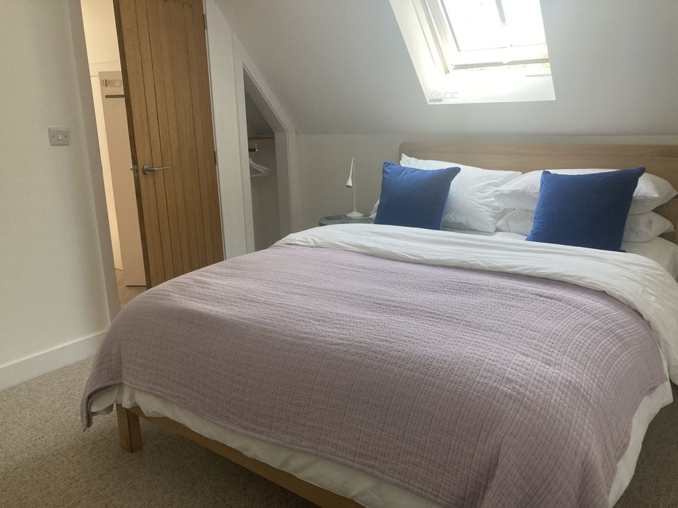 A bedroom with a bed and wooden door at Jams in Lympstone
