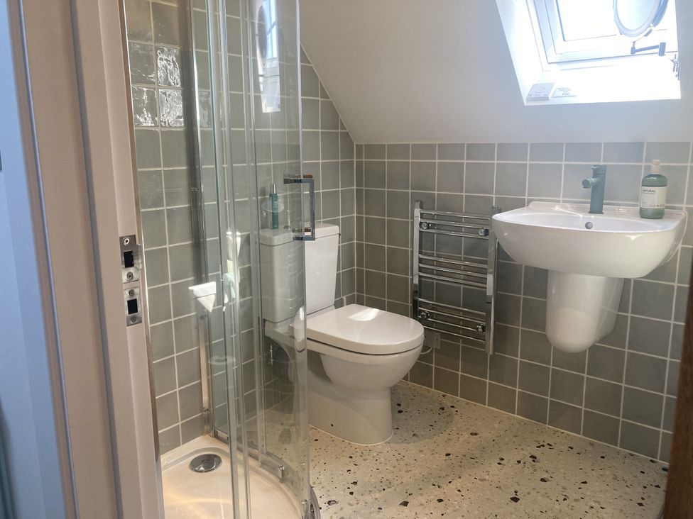 A bathroom with a shower, toilet, and sink at Jams in Lympstone