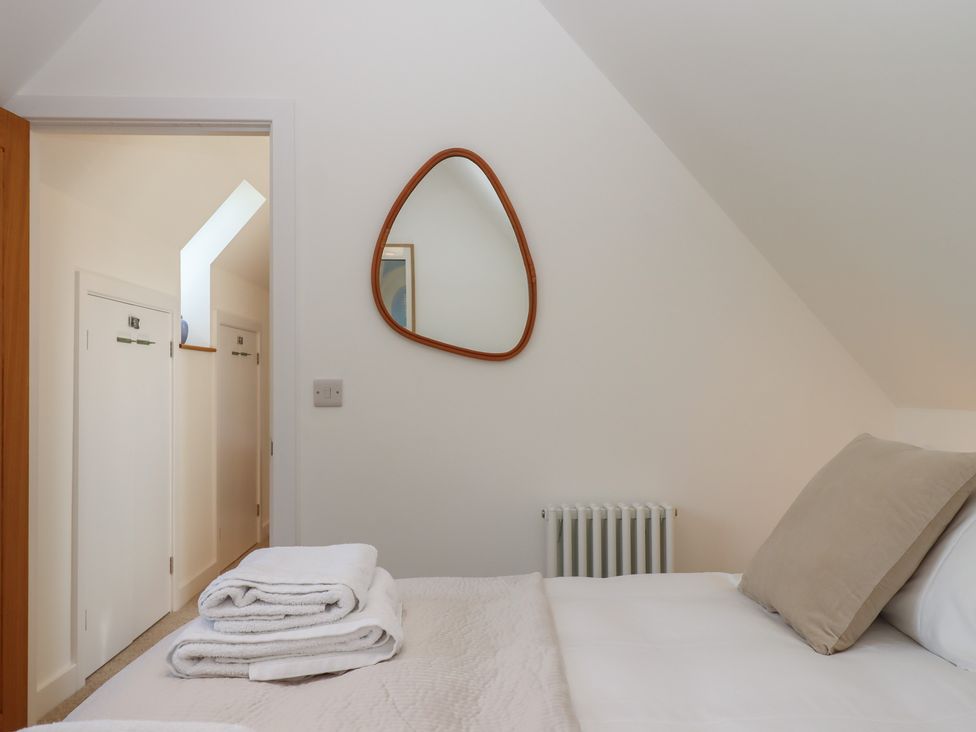 A bedroom with a bed and a mirror at Jams in Lympstone