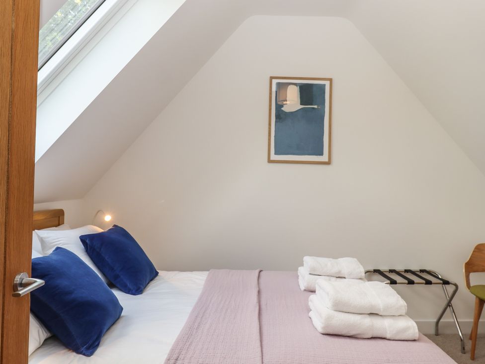 A bedroom with a bed and towels at Jams in Lympstone