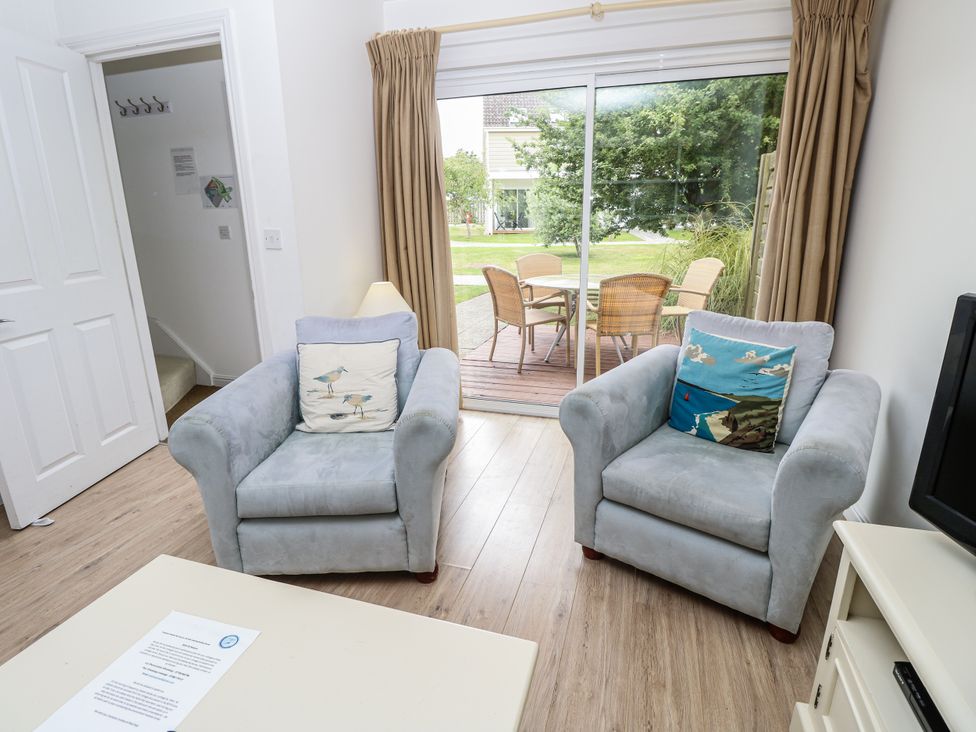 A living room with two armchairs and a view of the dining area at Vermont 4 Yarmouth