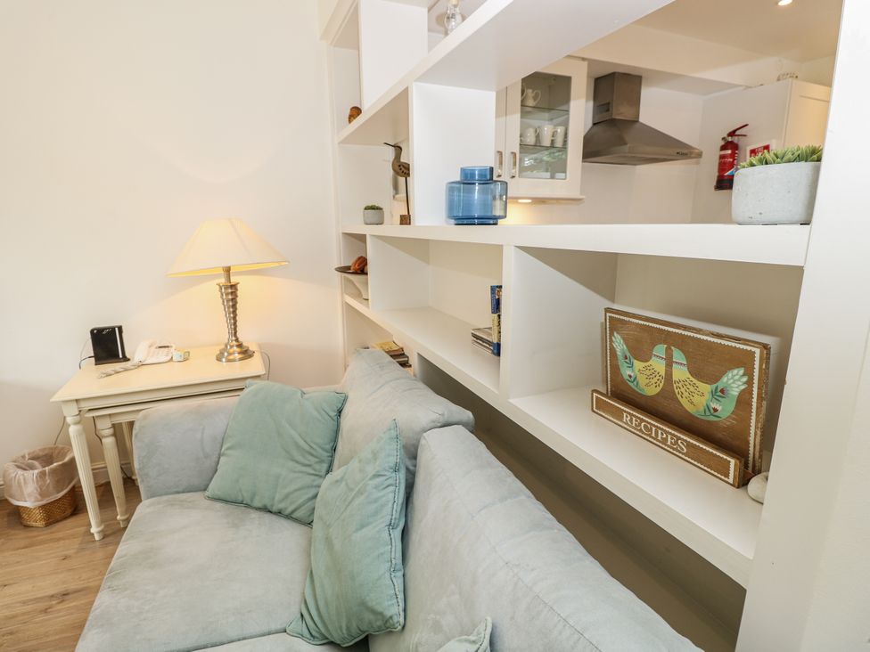 A living room with a sofa, lamp, and bookshelves at Vermont 4 in Yarmouth