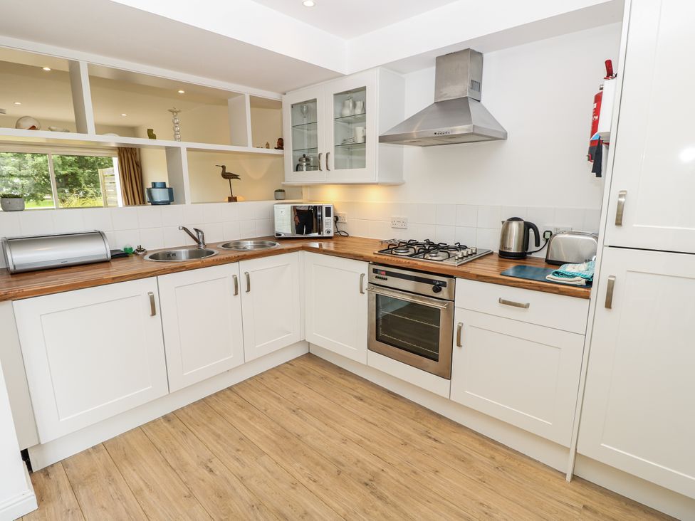 A kitchen with an oven, sink, and microwave at Vermont 4 in Yarmouth