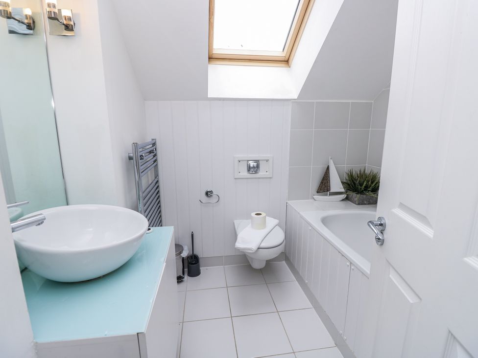 A bathroom with a bathtub, toilet, and sink at Vermont 4 Yarmouth