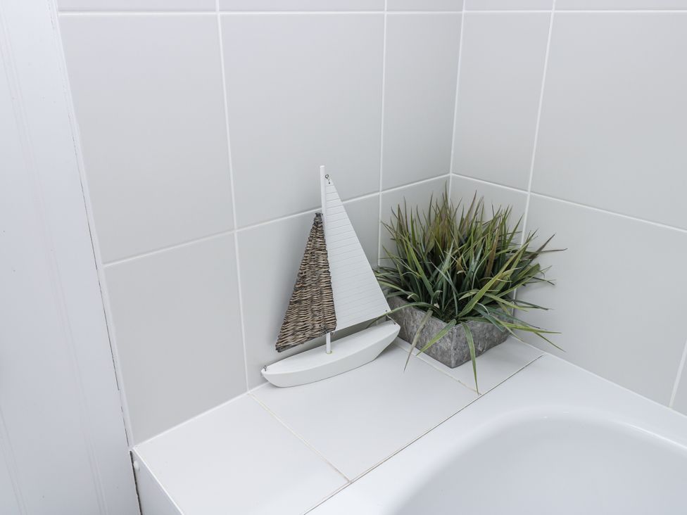 A bathtub with a sailboat and an artificial plant at Vermont 4 in Yarmouth