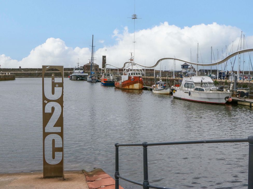 A harbor with boats and a sign at Duncan Square in Whitehaven