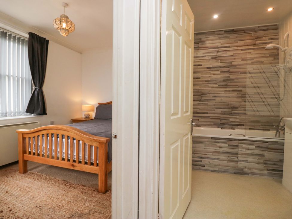 A bedroom with a bed and connecting bathroom at Duncan Square Whitehaven