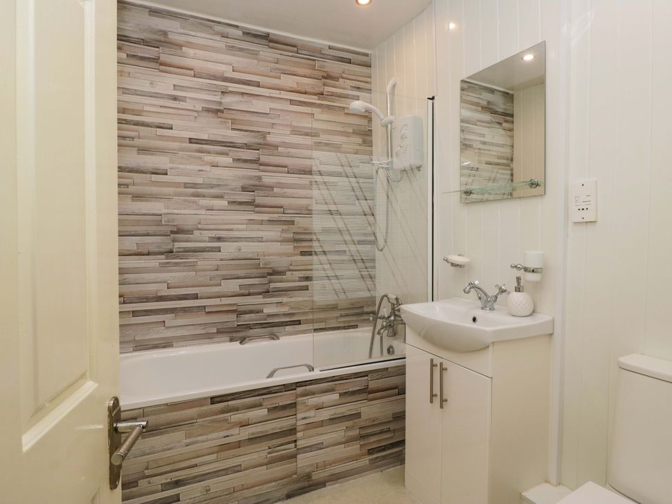 A bathroom with a bathtub, sink, and shower at Duncan Square in Whitehaven