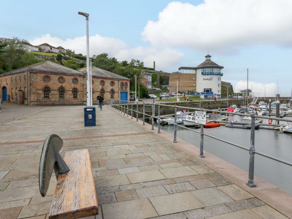 A marina with boats and buildings along the walkway at Duncan Square in Whitehaven