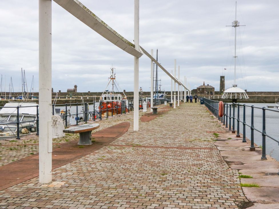A pier with boats and benches at Duncan Square Whitehaven