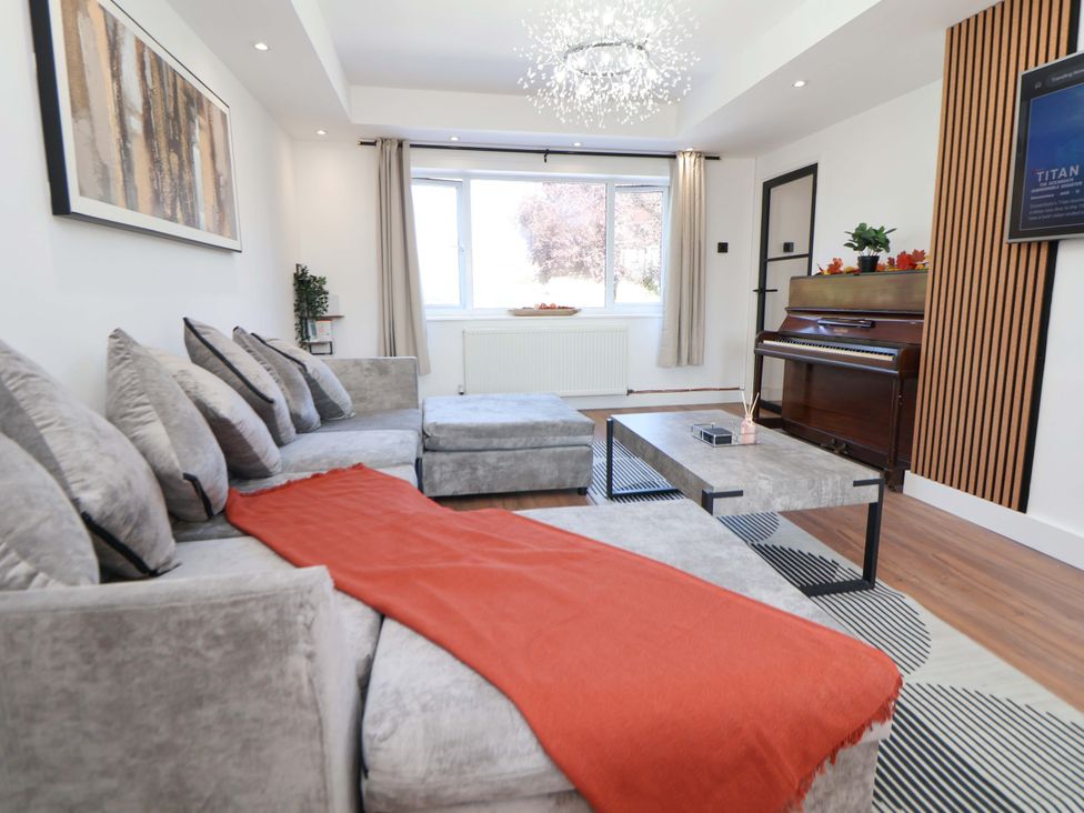 A living room with a sofa and piano at 11 Coniston Road Chester