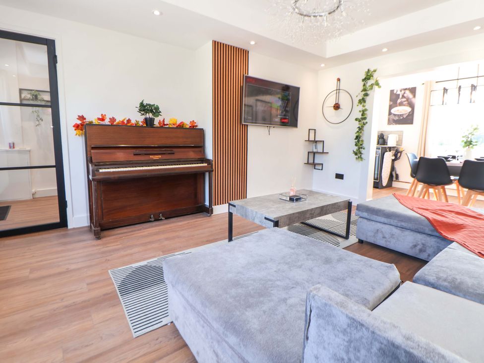 A living room with a piano and television at 11 Coniston Road in Chester