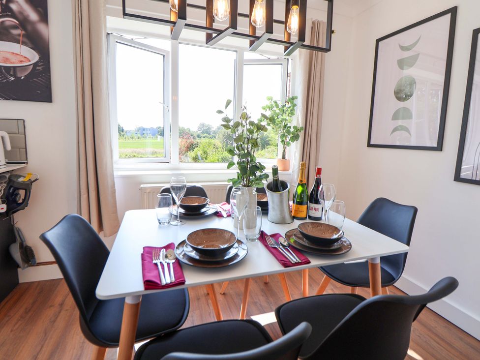 A dining room with a table set for meals at 11 Coniston Road in Chester