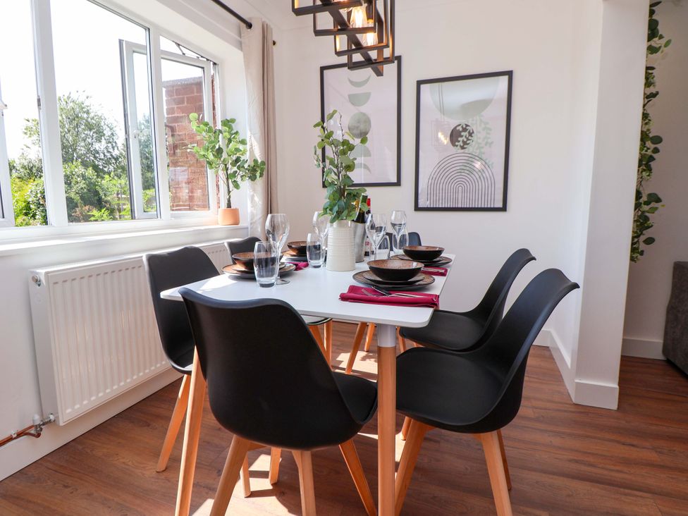 A dining room with a table set for meals at 11 Coniston Road Chester