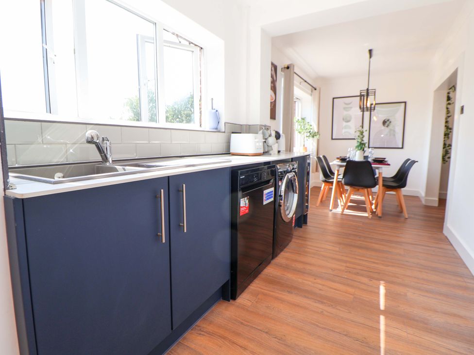 A kitchen with a sink and washing machine at 11 Coniston Road in Chester