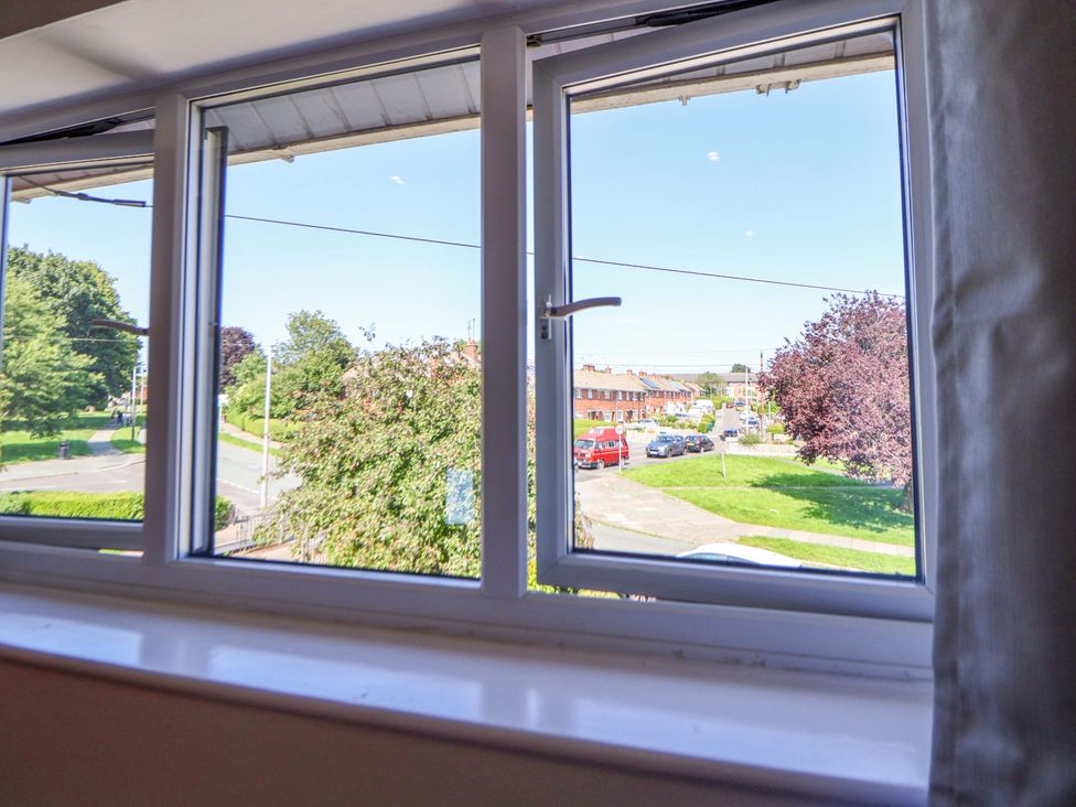 A window view showing trees, a road, and parked cars at 11 Coniston Road Chester
