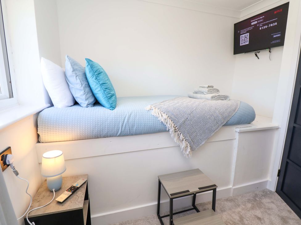 A bedroom with a bed and shelves at 11 Coniston Road Chester