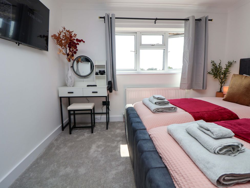 A bedroom with a bed and vanity table at 11 Coniston Road Chester