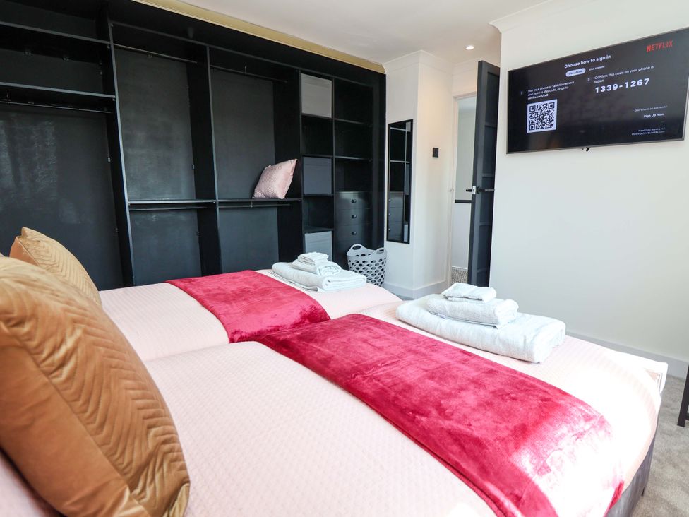A bedroom with two beds and a television at 11 Coniston Road Chester