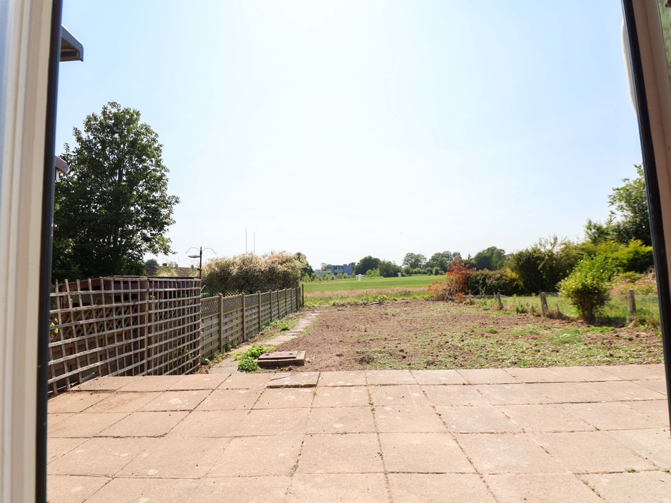 A garden view with a patio and trees at 11 Coniston Road Chester