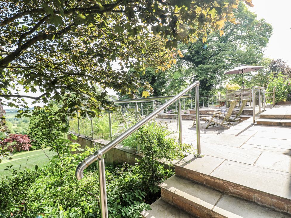 A garden with stairs leading to a seating area at The View @ Orchard View in Hognaston