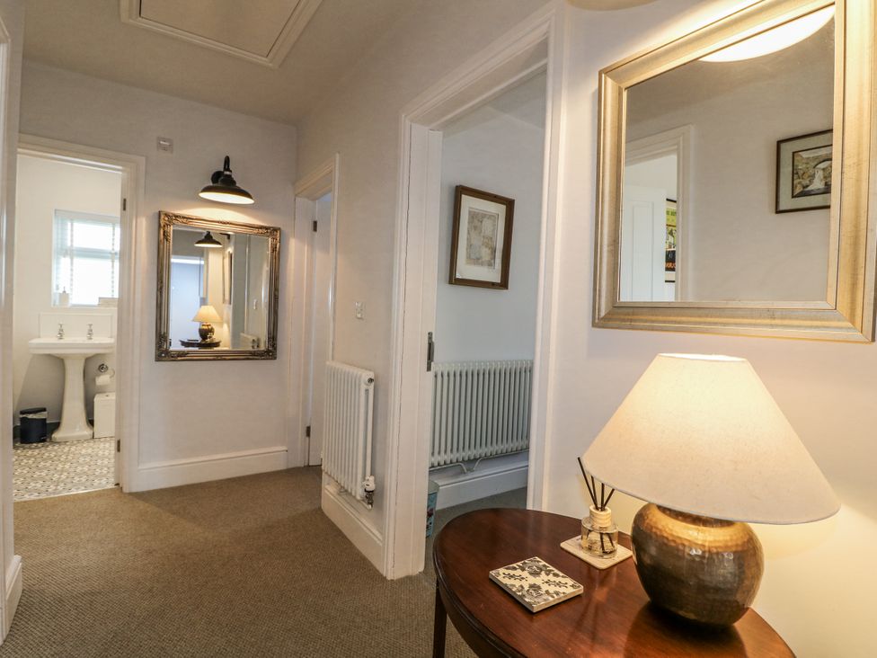 A hallway with a mirror and lamp at The View @ Orchard View in Hognaston