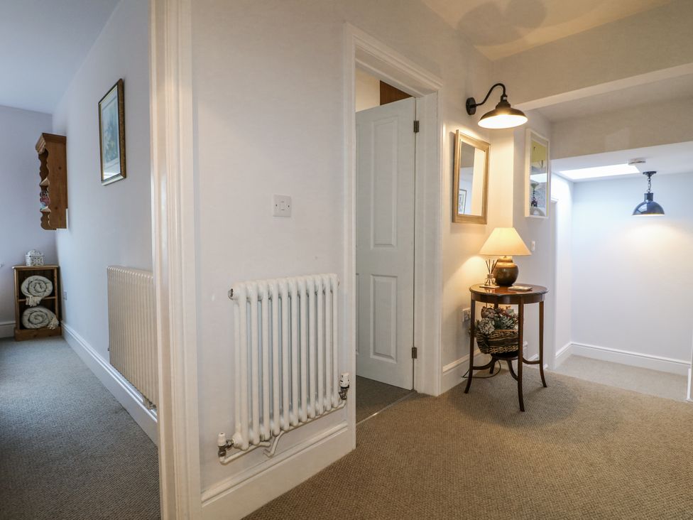 A hallway with a radiator and a table at The View @ Orchard View in Hognaston