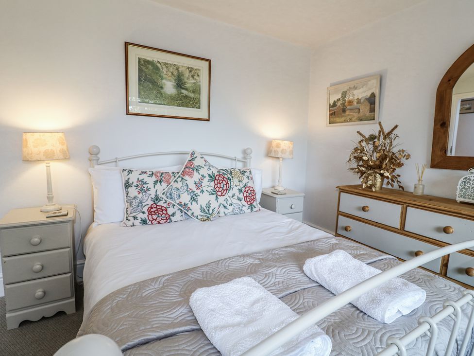 A bedroom with a bed and decorative items at The View @ Orchard View Hognaston