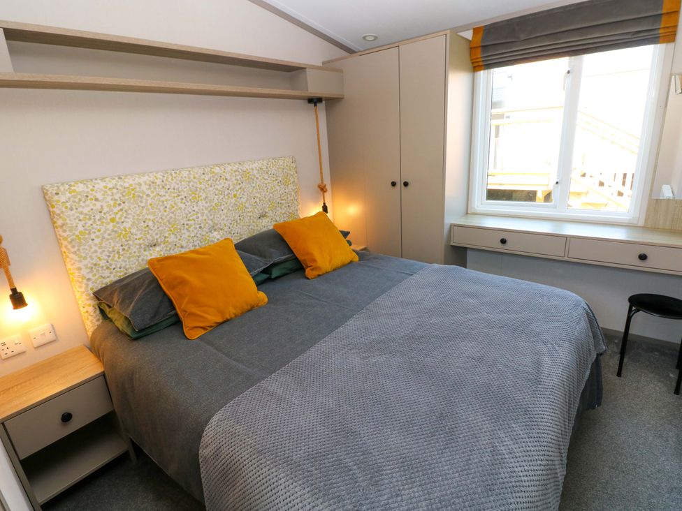 A bedroom with a bed and wardrobe at No 13 Broadfield Farm Holiday Park in Saundersfoot