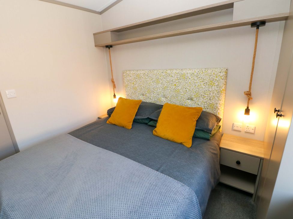 A bedroom with a bed and bedside table at No 13 Broadfield Farm Holiday Park, Saundersfoot